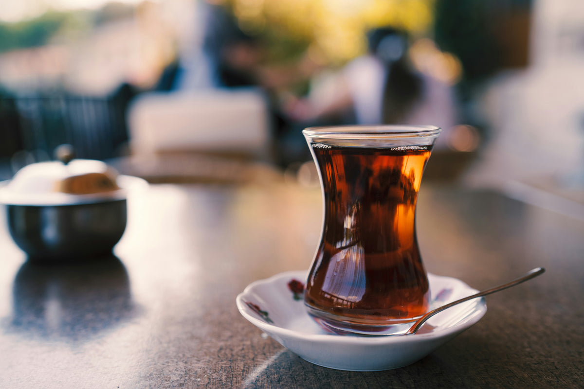 Turkish tea in a tulip glass on a white saucer